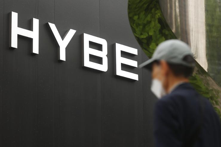 A man is seen walking past the headquarters of HYBE.
Image Source: The Korea Times