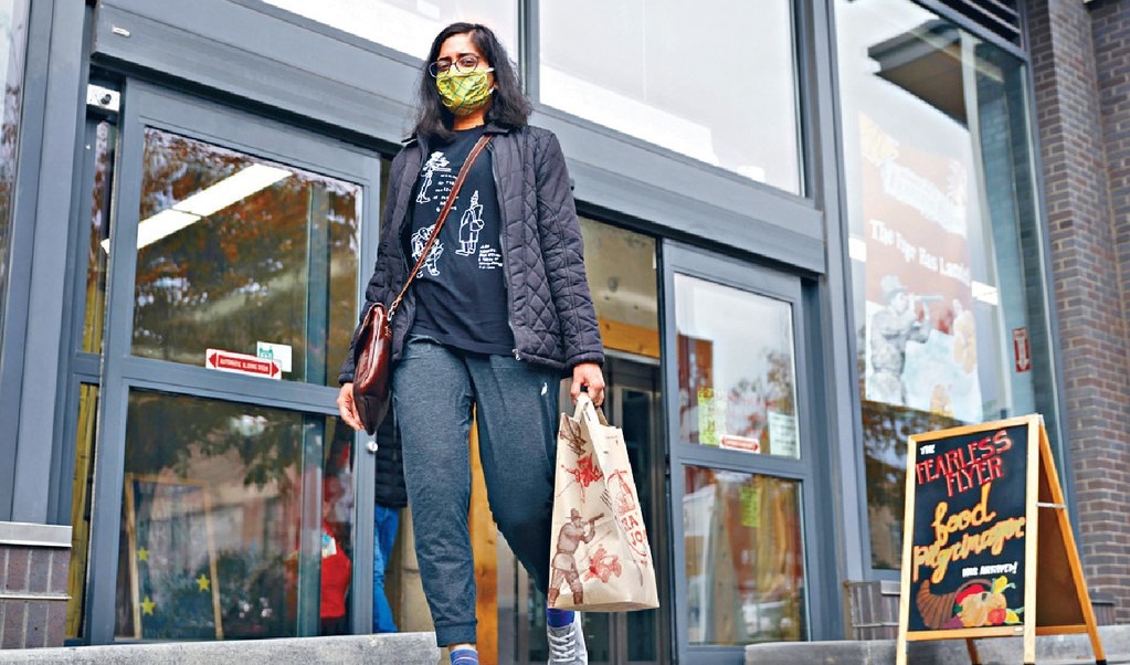 a woman just bought something and go out from a shop, which shows a consumer confidence and high inflation