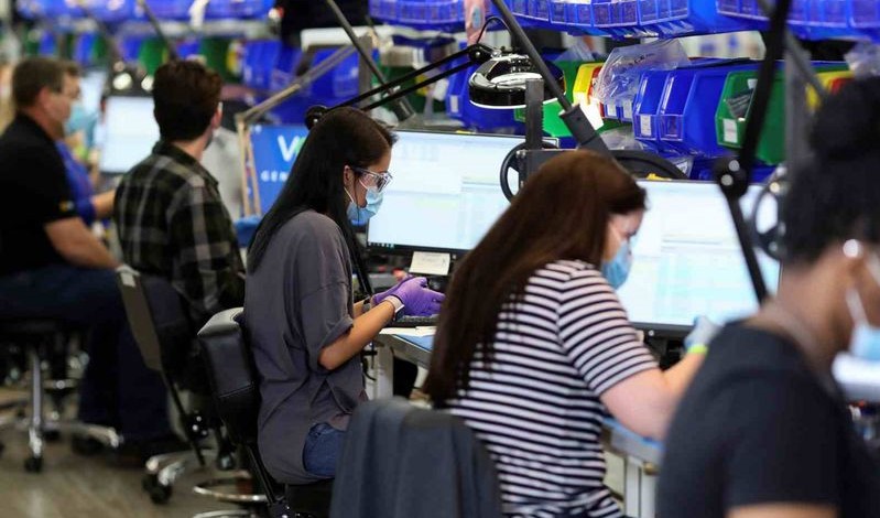 Many works are sitting in front of computers and working in manufacture factory showing employment, labor force and ADP