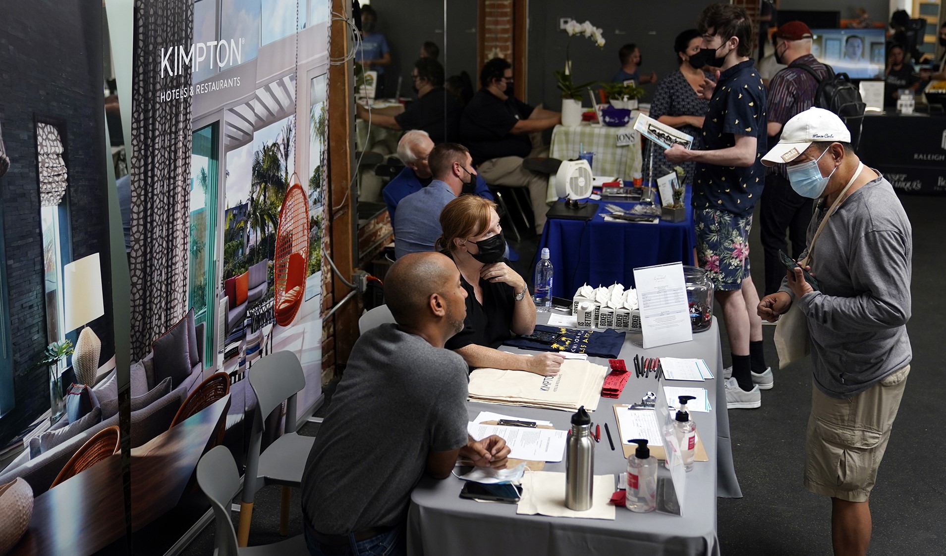 A man and a woman are sitting and looking to a man who is looking for a job, which shows a high employment rate is USA